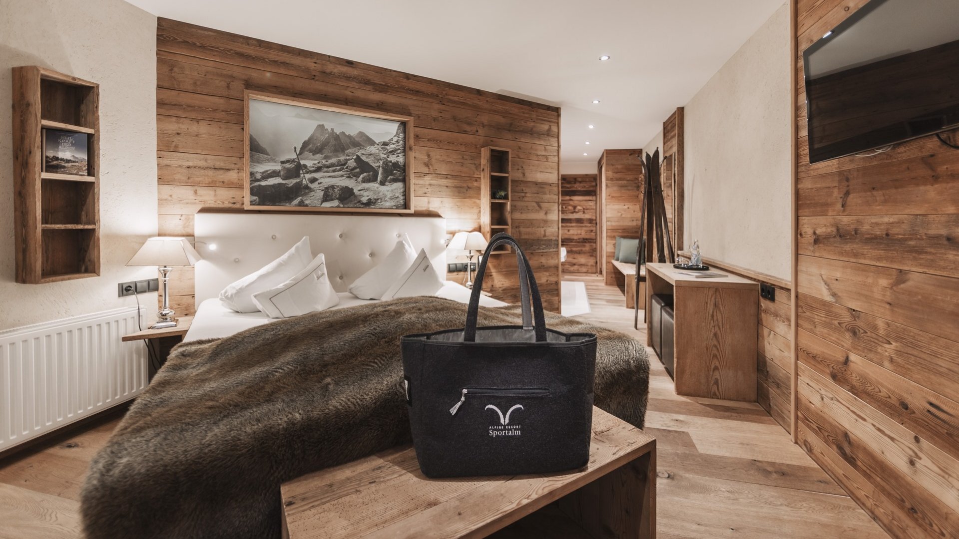Everything about your Sportalm holiday Modern hotel room with wooden walls and bed with fur blanket
