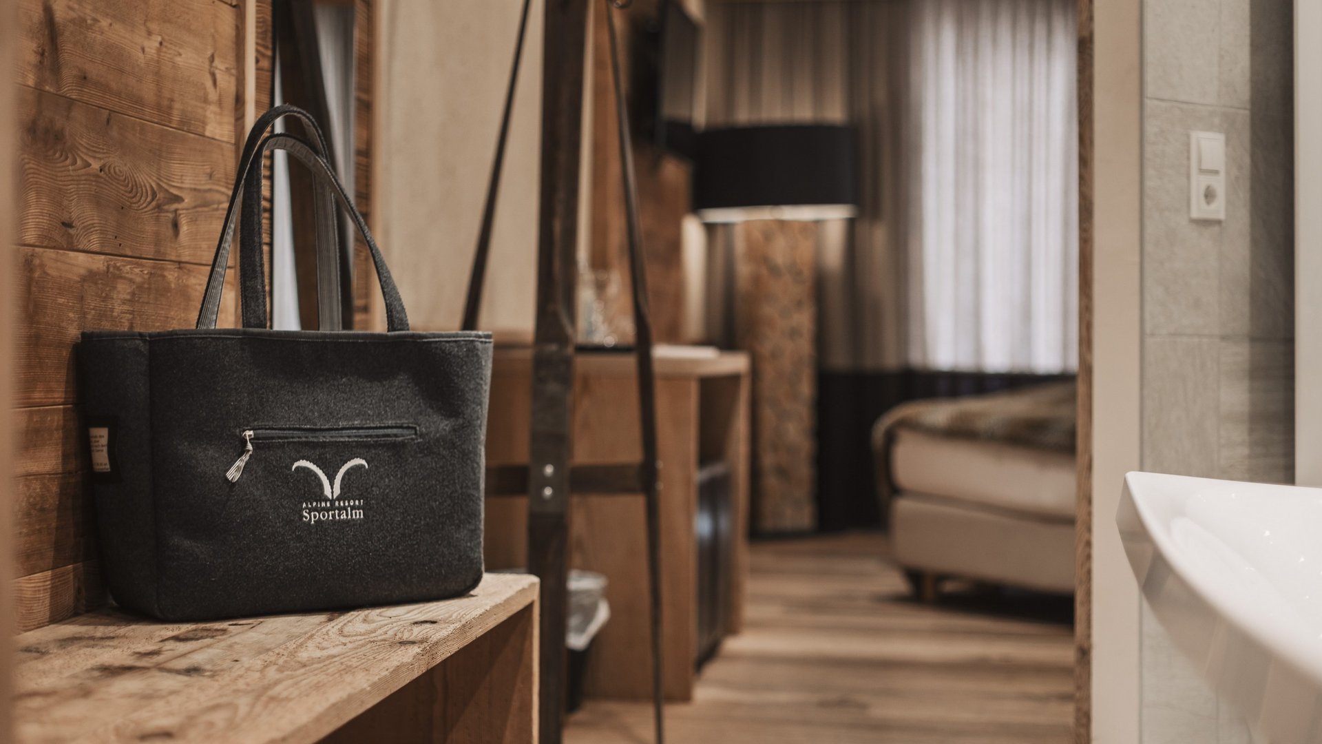 Everything about your Sportalm holiday Black bag on wooden bench in cozy room with wooden floor