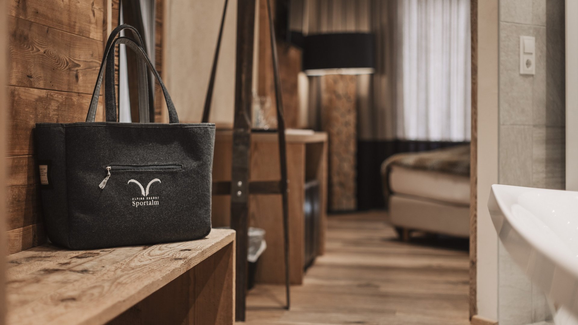 Starke Inklusivleistungen Schwarze Tasche auf Holzbänkchen in gemütlichem Zimmer mit Holzfußboden