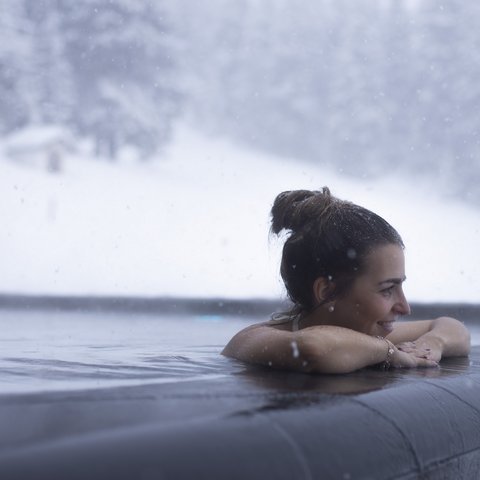 Bilder aus der Sportalm Frau entspannt im beheizten Außenpool bei Schneefall