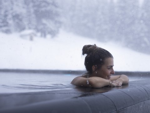 Pictures from Sportalm Woman relaxing in heated outdoor pool while snow is falling