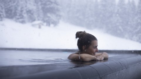 Bilder aus der Sportalm Frau entspannt im beheizten Außenpool bei Schneefall