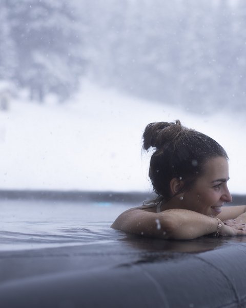 Bilder aus der Sportalm Frau entspannt im beheizten Außenpool bei Schneefall