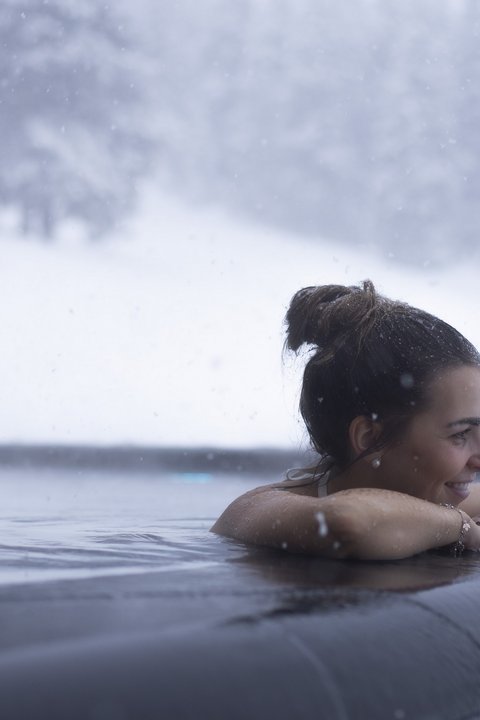 Pictures from Sportalm Woman relaxing in heated outdoor pool while snow is falling