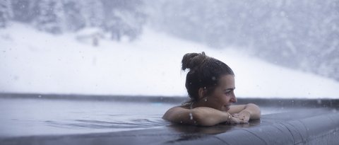 Bilder aus der Sportalm Frau entspannt im beheizten Außenpool bei Schneefall