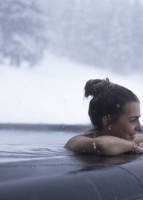 Pictures from Sportalm Woman relaxing in heated outdoor pool while snow is falling