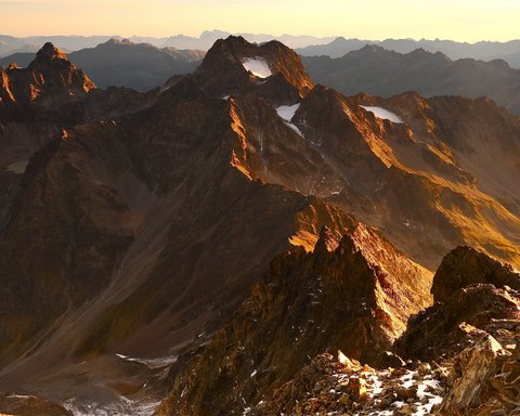 Pictures from Sportalm Mountain peaks bathed in golden sunlight at sunset in the Alps