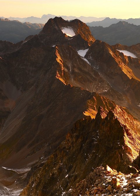Pictures from Sportalm Mountain peaks bathed in golden sunlight at sunset in the Alps