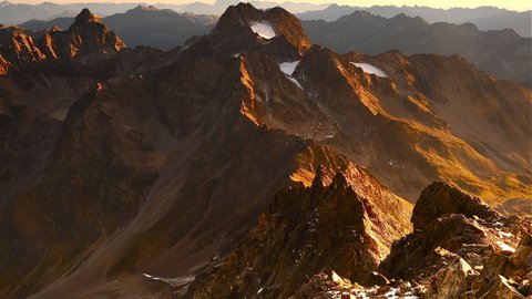 Bilder aus der Sportalm Berggipfel im goldenen Sonnenlicht bei Sonnenuntergang im Gebirge