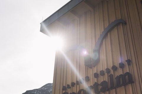 Bilder aus der Sportalm Gebäudewand mit Alpine Resort Sportalm Schriftzug im Sonnenlicht