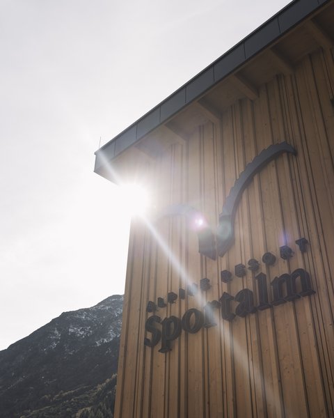 Bilder aus der Sportalm Gebäudewand mit Alpine Resort Sportalm Schriftzug im Sonnenlicht