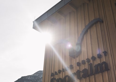 Bilder aus der Sportalm Gebäudewand mit Alpine Resort Sportalm Schriftzug im Sonnenlicht