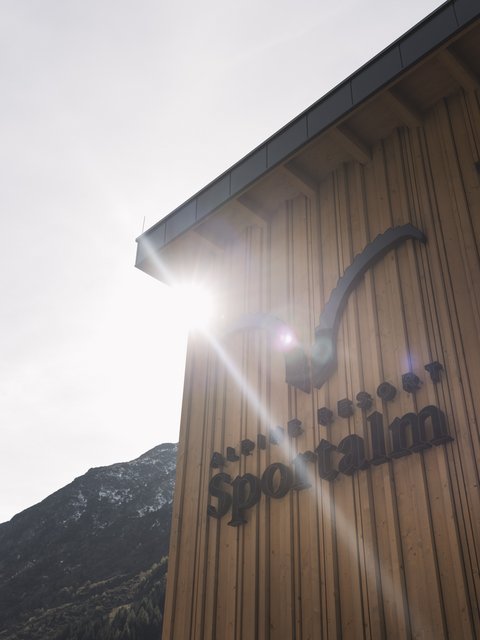 Bilder aus der Sportalm Gebäudewand mit Alpine Resort Sportalm Schriftzug im Sonnenlicht