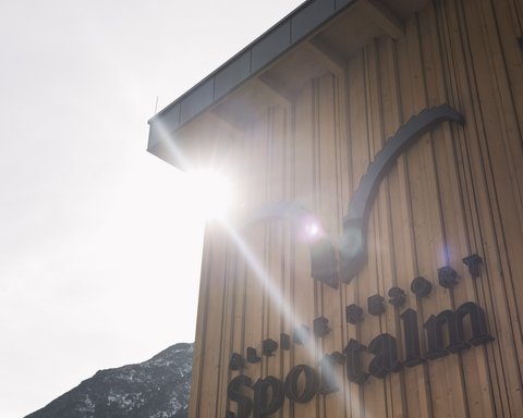 Bilder aus der Sportalm Gebäudewand mit Alpine Resort Sportalm Schriftzug im Sonnenlicht