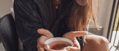 Pictures from Sportalm Woman in bathrobe holding a cup of tea smiling