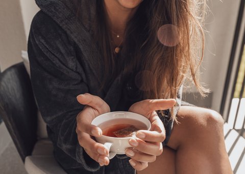 Pictures from Sportalm Woman in bathrobe holding a cup of tea smiling