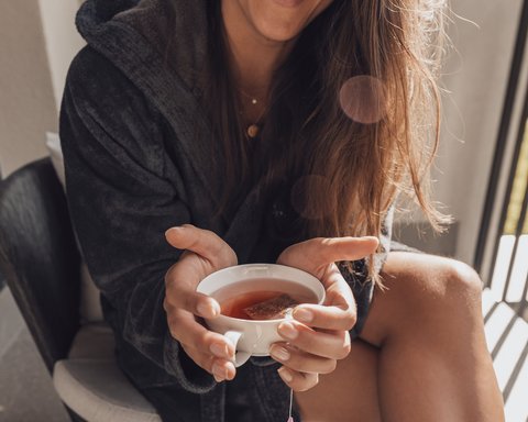 Pictures from Sportalm Woman in bathrobe holding a cup of tea smiling
