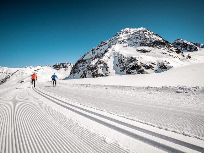 Nicht irgendein Pitztal-Resort: Alpine Resort Sportalm! Zwei Langläufer auf frisch gespurter Loipe in verschneiter Berglandschaft