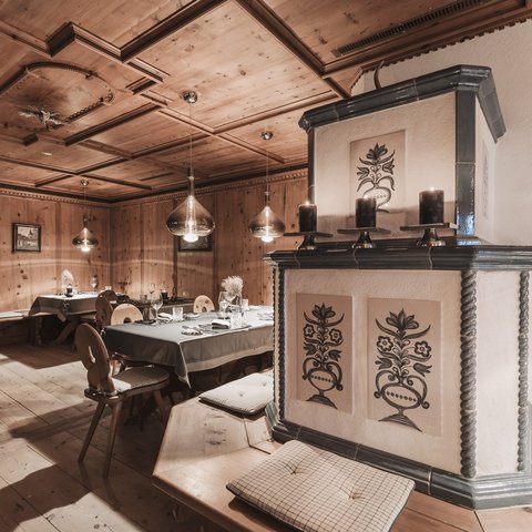 Pictures from Sportalm Cozy wooden room with decorative stove and set dining tables
