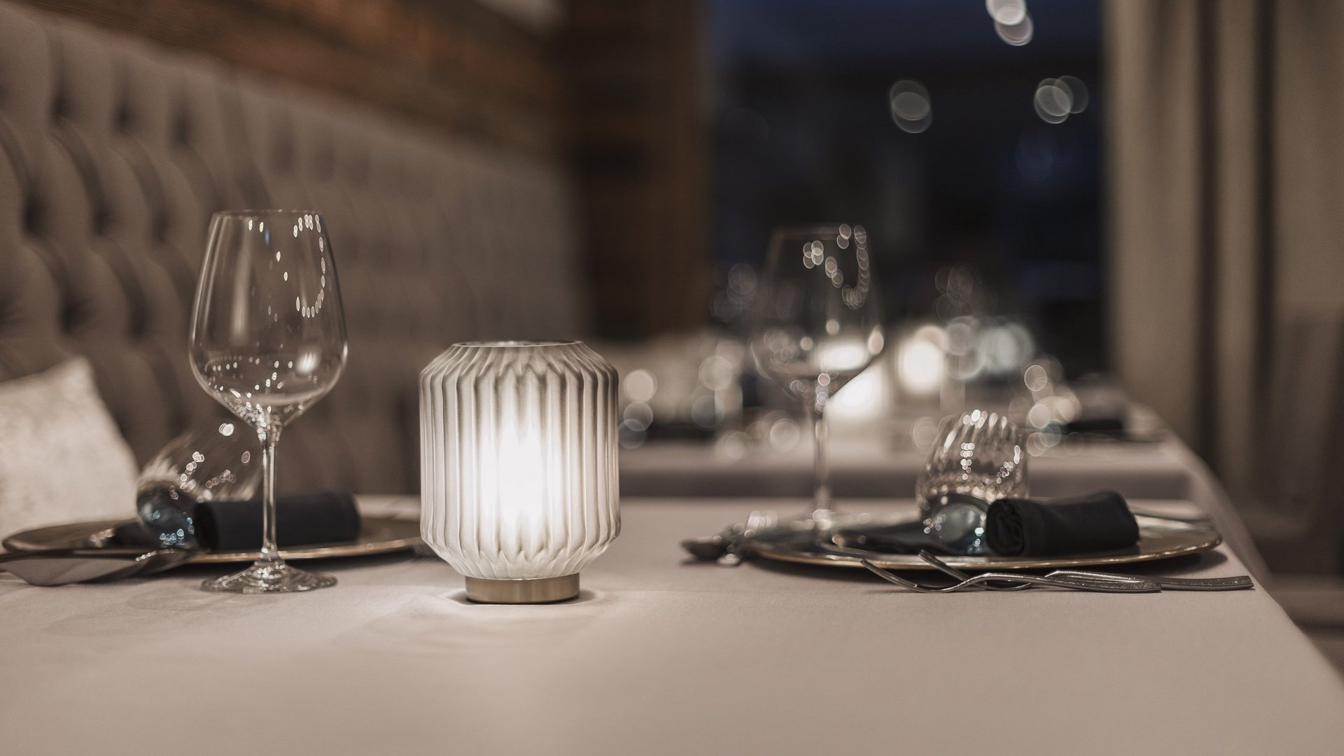 Starke Inklusivleistungen Elegantes Restaurant-Tischgedeck mit Kerzenlicht und Weingläsern