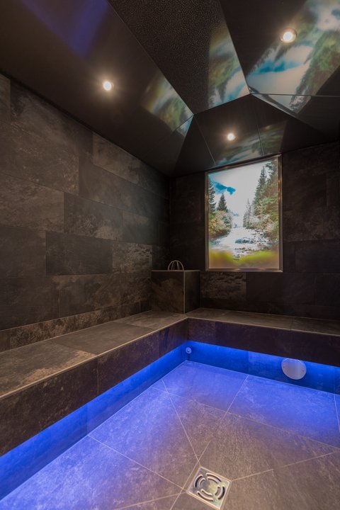 Pictures from Sportalm Modern spa room with dark tiles and blue floor lighting