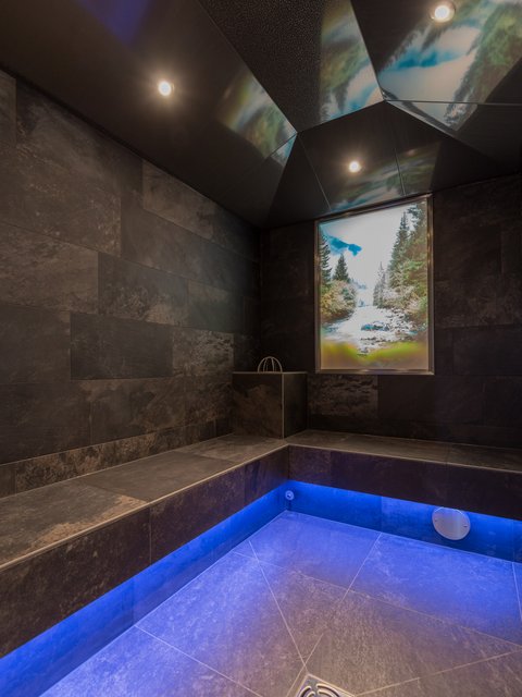 Pictures from Sportalm Modern spa room with dark tiles and blue floor lighting
