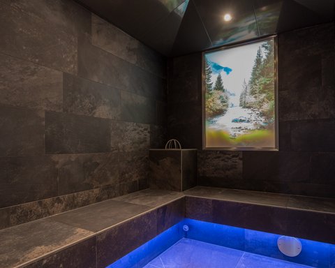 Pictures from Sportalm Modern spa room with dark tiles and blue floor lighting