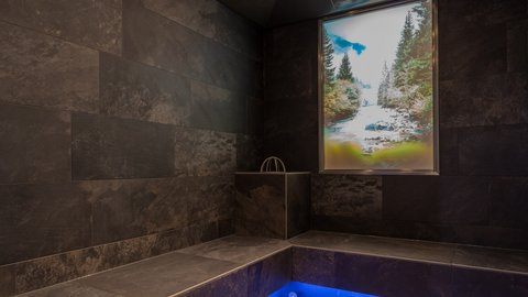 Pictures from Sportalm Modern spa room with dark tiles and blue floor lighting