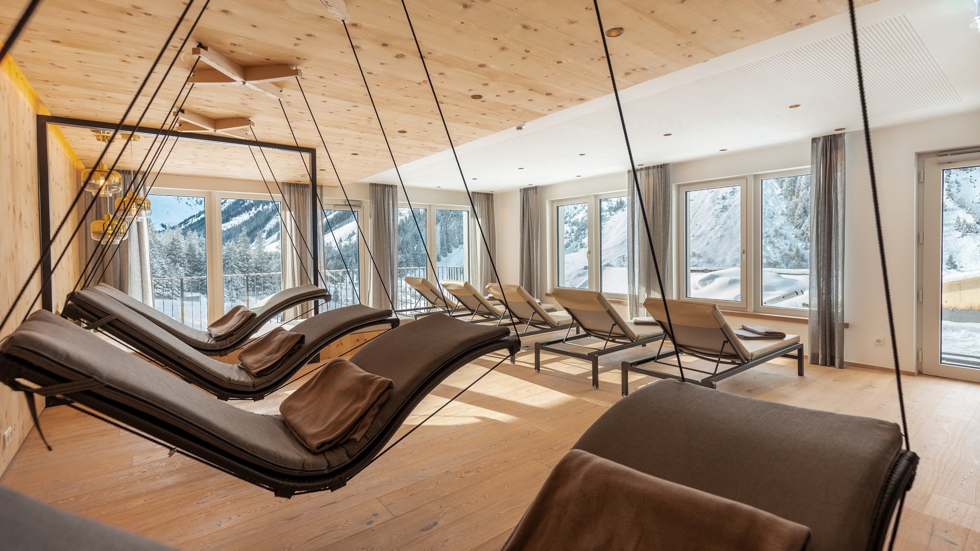Urlaub im Pitztal? Unterkunft mit Pep! Helle Ruheraum mit Schaukelliegen und Blick auf verschneite Berge