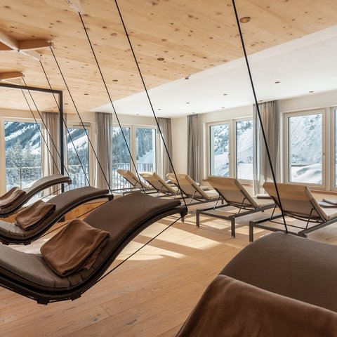 Bilder aus der Sportalm Helle Ruheraum mit Schaukelliegen und Blick auf verschneite Berge