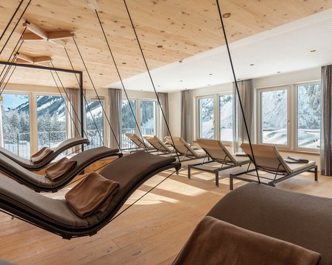 Bilder aus der Sportalm Helle Ruheraum mit Schaukelliegen und Blick auf verschneite Berge