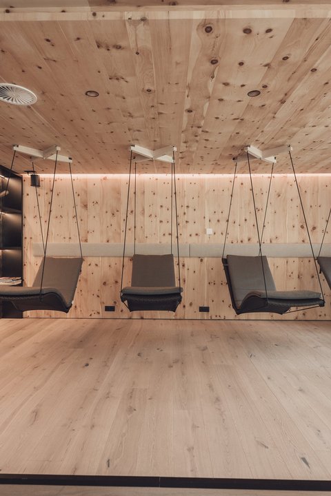 Pictures from Sportalm Modern relaxation room with wooden walls and hanging lounge chairs