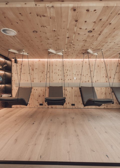 Pictures from Sportalm Modern relaxation room with wooden walls and hanging lounge chairs