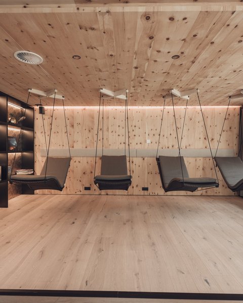 Pictures from Sportalm Modern relaxation room with wooden walls and hanging lounge chairs