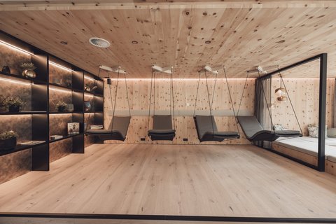 Pictures from Sportalm Modern relaxation room with wooden walls and hanging lounge chairs