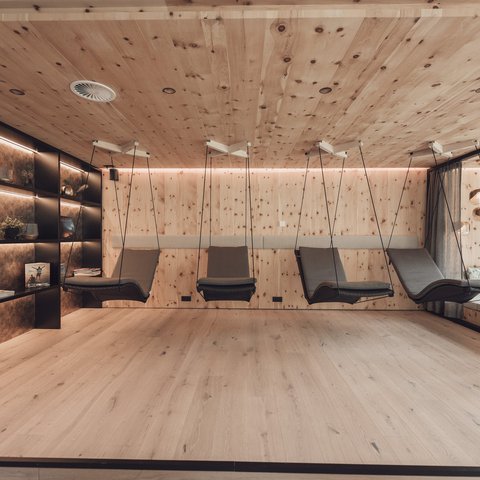 Pictures from Sportalm Modern relaxation room with wooden walls and hanging lounge chairs