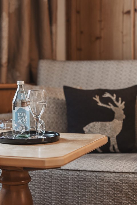 Pictures from Sportalm Cozy seating area with water bottle, glasses, and deer cushion on wooden paneling