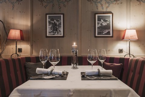 Bilder aus der Sportalm Gemütlicher Esstisch mit Kerze, zwei Gedecken und Lampen im Holzraum