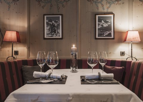 Bilder aus der Sportalm Gemütlicher Esstisch mit Kerze, zwei Gedecken und Lampen im Holzraum