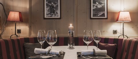 Bilder aus der Sportalm Gemütlicher Esstisch mit Kerze, zwei Gedecken und Lampen im Holzraum