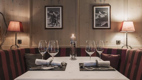 Bilder aus der Sportalm Gemütlicher Esstisch mit Kerze, zwei Gedecken und Lampen im Holzraum