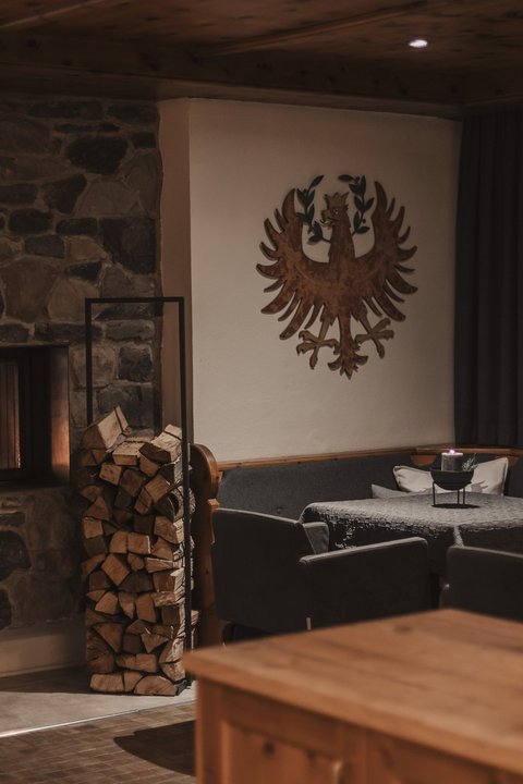 Pictures from Sportalm Cozy room with stone fireplace, stacked wood, and decorated walls
