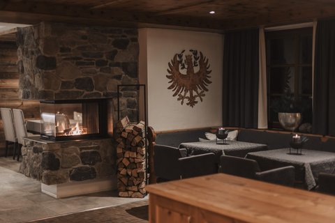 Pictures from Sportalm Cozy room with stone fireplace, stacked wood, and decorated walls