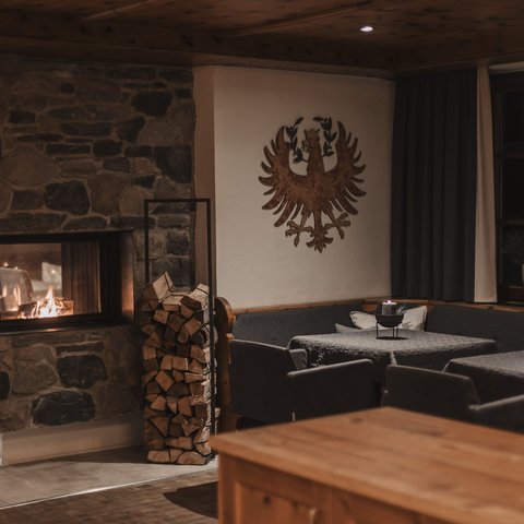 Pictures from Sportalm Cozy room with stone fireplace, stacked wood, and decorated walls