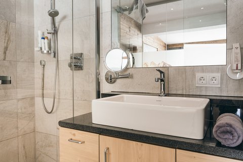 Bilder aus der Sportalm Helles Badezimmer mit Waschbecken, Spiegel und Dusche